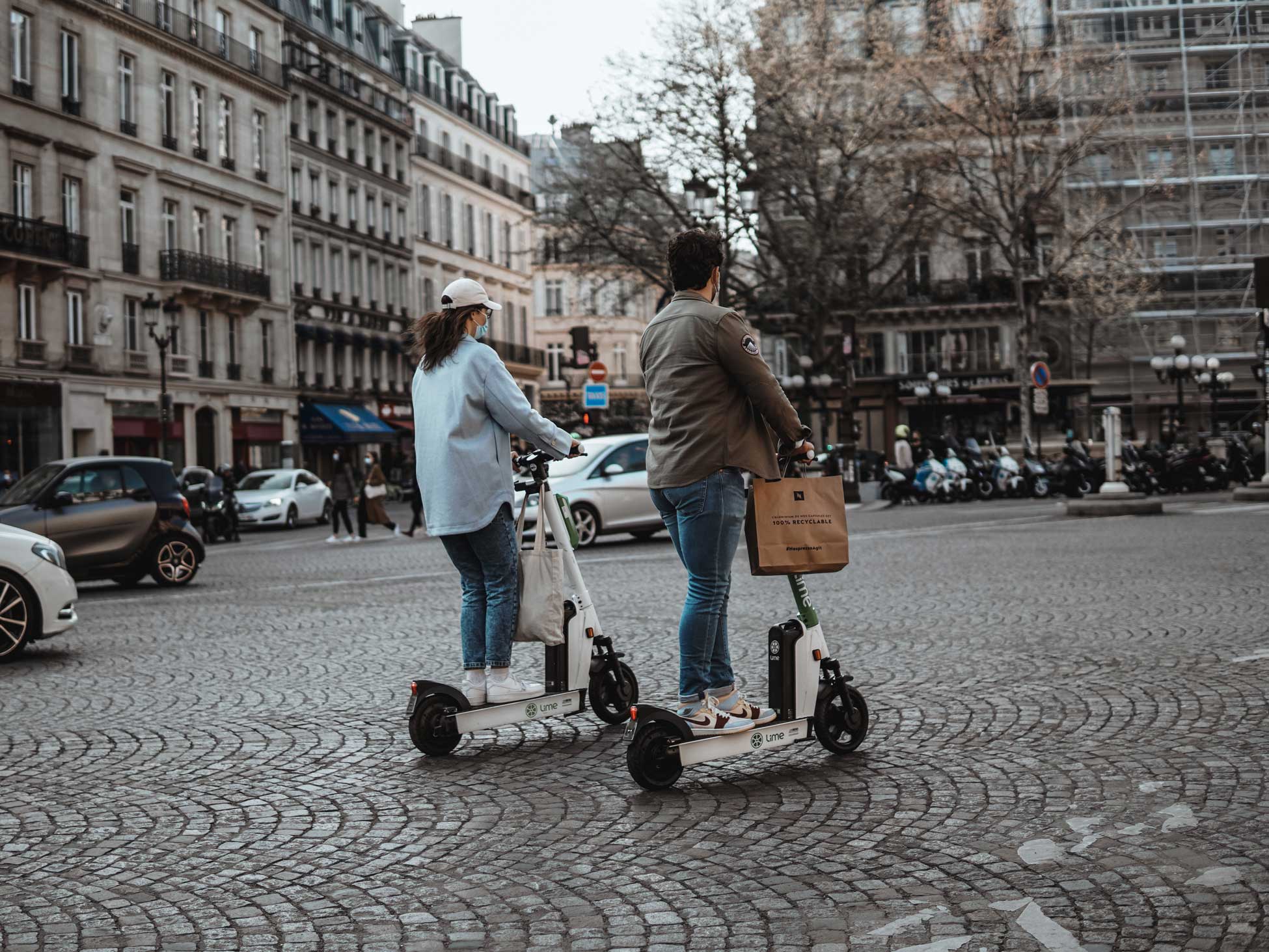 2 persons riding on electric scooters