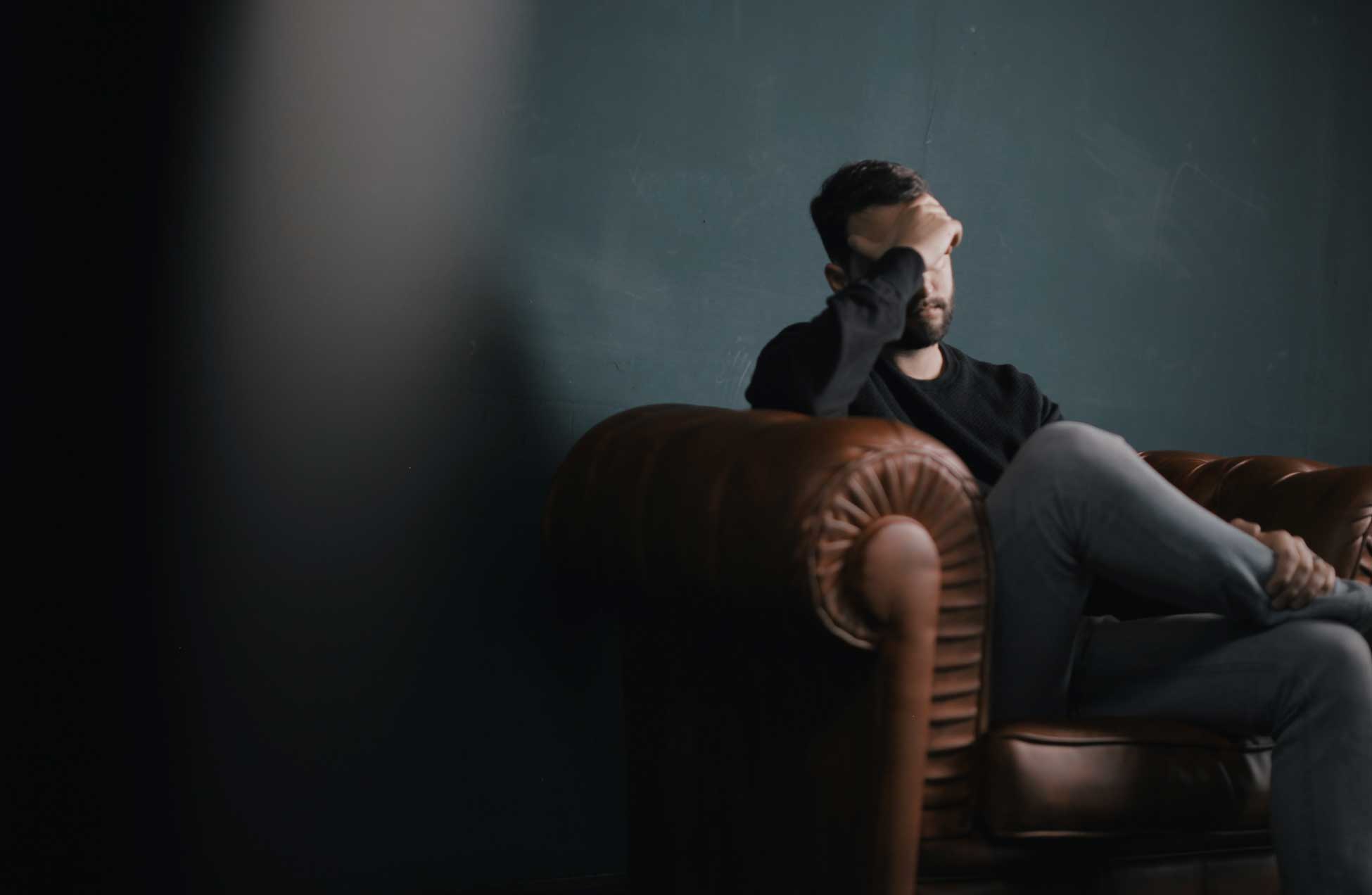 a concerned man sitting on a couch