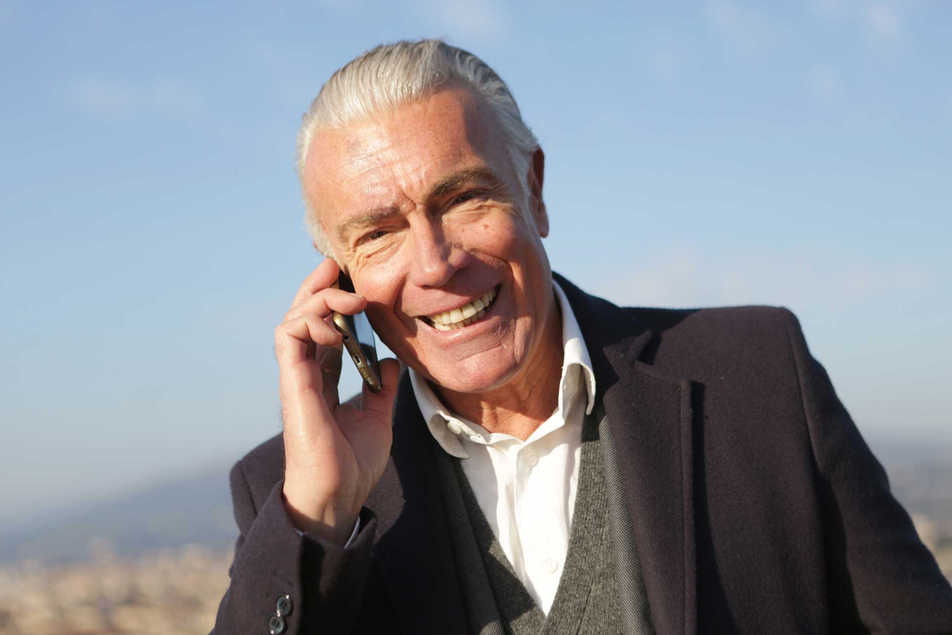a happy man making on a phone call