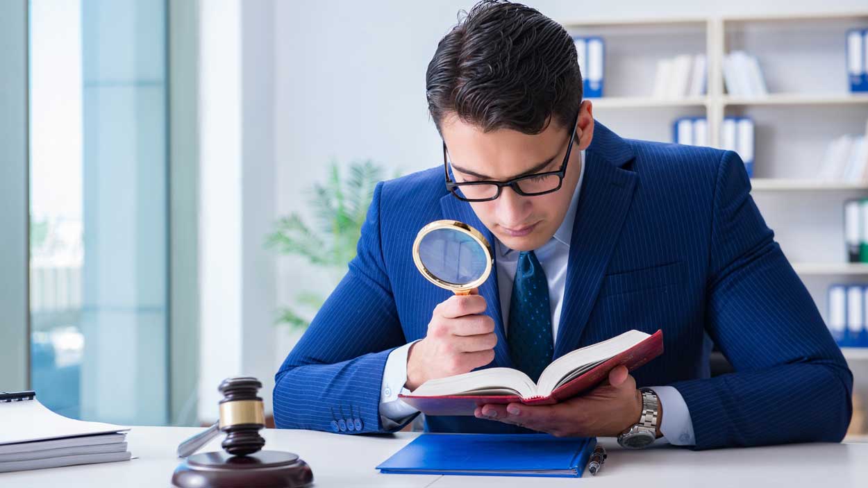a man reading a book using a magnifying glass
