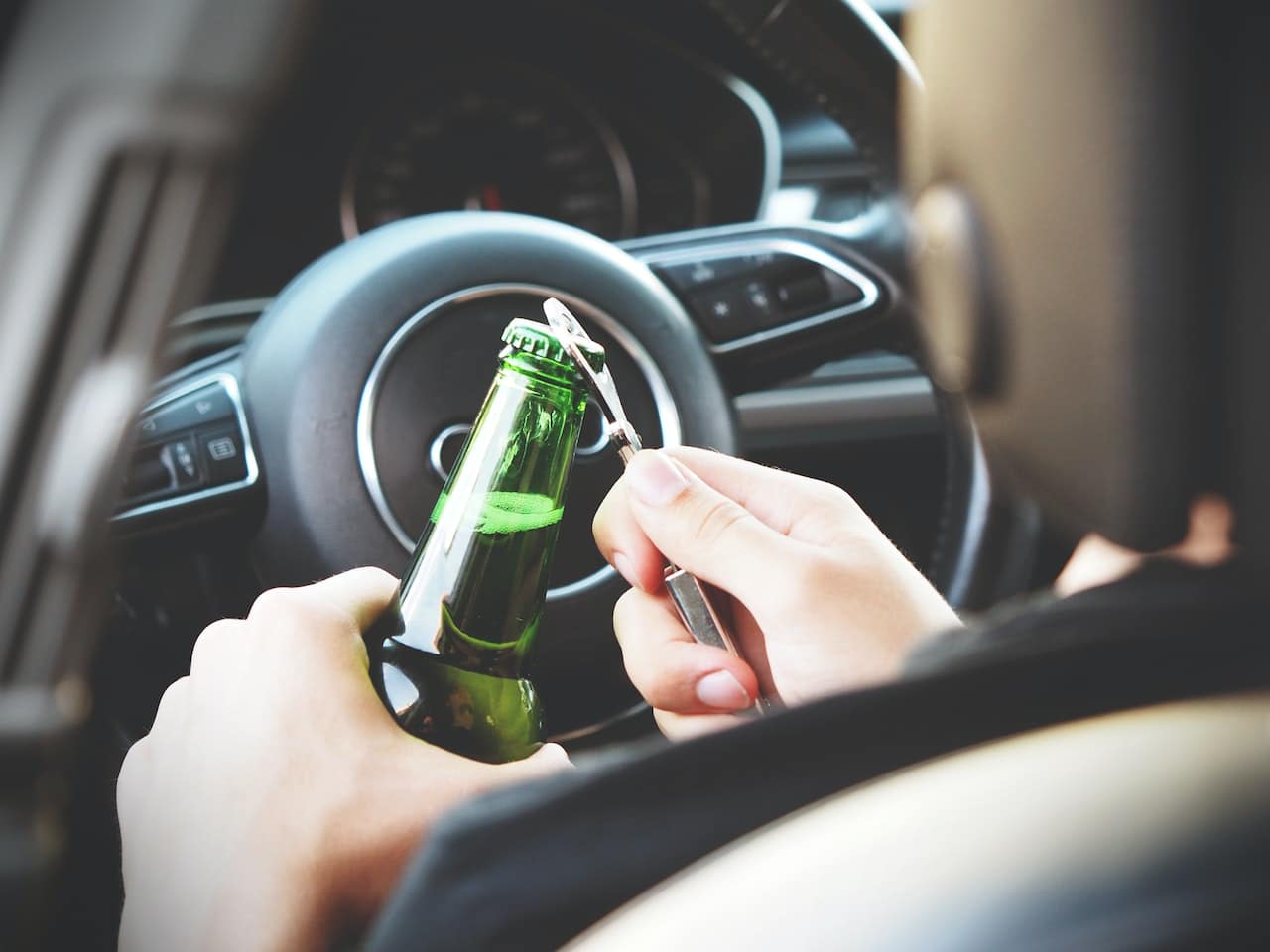 opening a beer bottle while behind the wheel